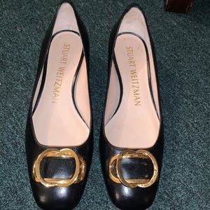 Black heeled shoes with gold buckle on top